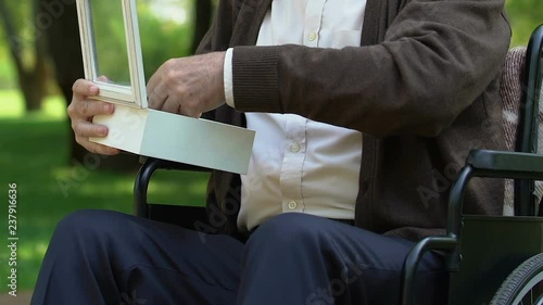 Handicapped old man opening box with medal of war, stressful memories of youth photo