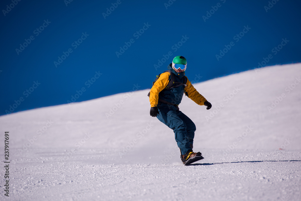snowboarder running down the slope and ride free style snowboarder running down the slope and ride free style