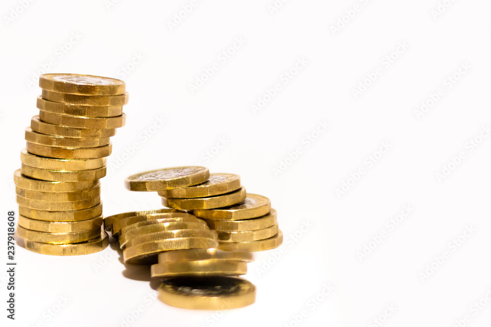 Stacks and Heaps of British GBP Golden Coins Currency Money on white background with empty space Stacks and Heaps of British GBP Golden Coins Currency Money on white background with empty space