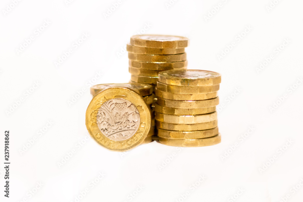 Stacks and Heaps of British GBP Golden Coins Currency Money on white background with empty space Stacks and Heaps of British GBP Golden Coins Currency Money on white background with empty space