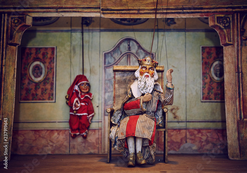 Handmade wooden puppet theater. King and Jester - clown. Selective focus