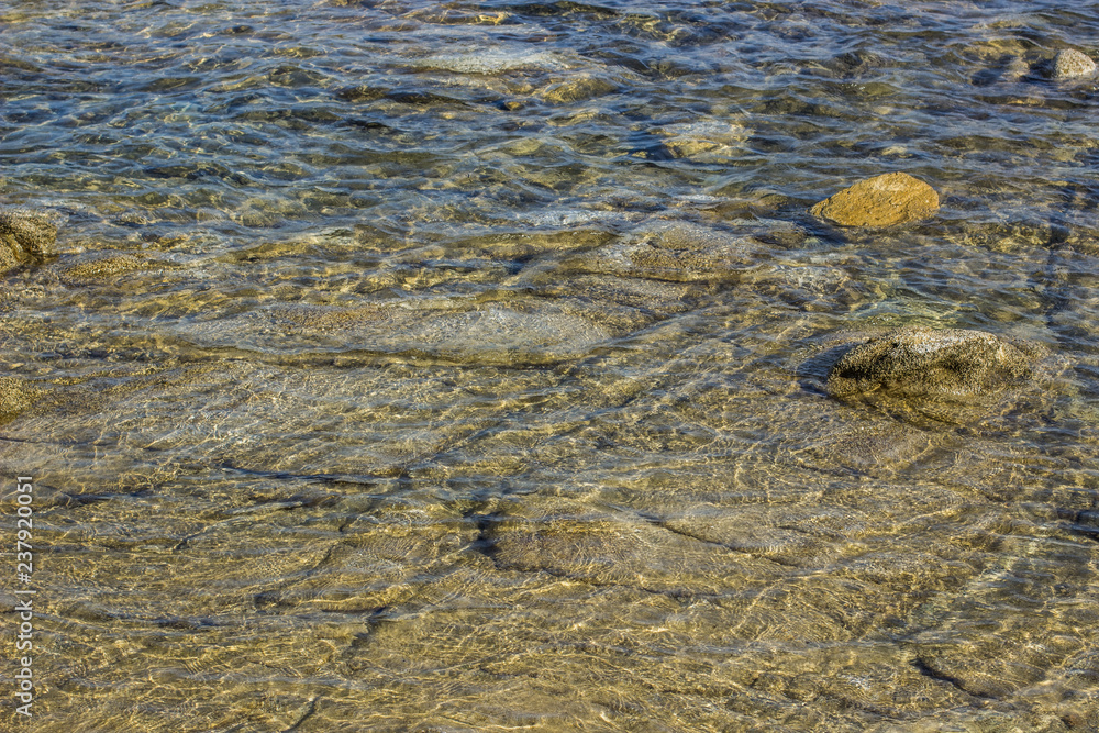 stones in vivid blue transparent sea water beach shore line south Mediterranean landscape