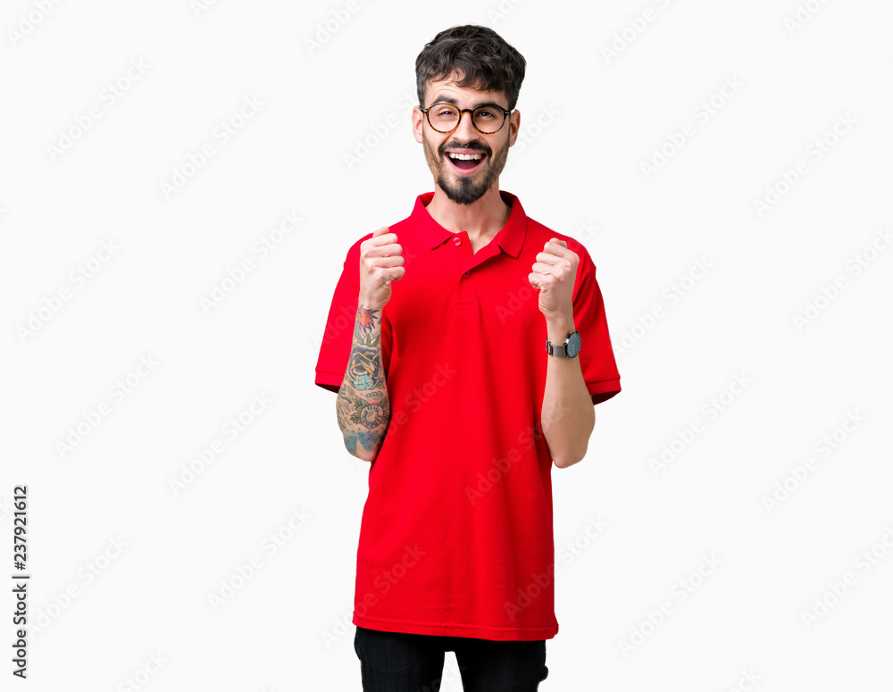 Young handsome man wearing glasses over isolated background celebrating surprised and amazed for success with arms raised and open eyes. Winner concept. Young handsome man wearing glasses over isolated background celebrating surprised and amazed for success with arms raised and open eyes. Winner concept.