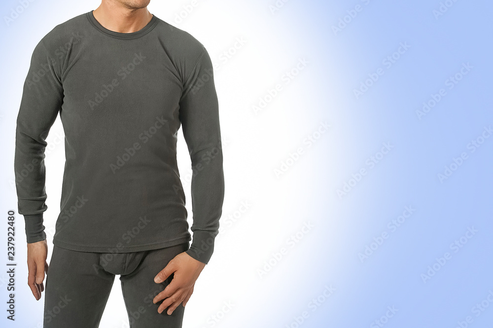 Man in thermal underwear for active winter sport. Man wearing Thermolinen isolated on blue background. T-shirt with long sleeves and leggings Man in thermal underwear for active winter sport. Man wearing Thermolinen isolated on blue background. T-shirt with long sleeves and leggings