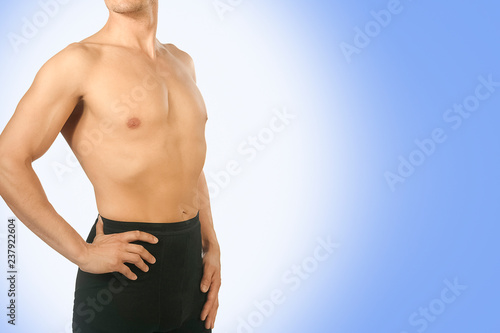 Male black thermal underwear for active winter sport. Man wearing Thermolinen on blue background. Topless, but in leggings