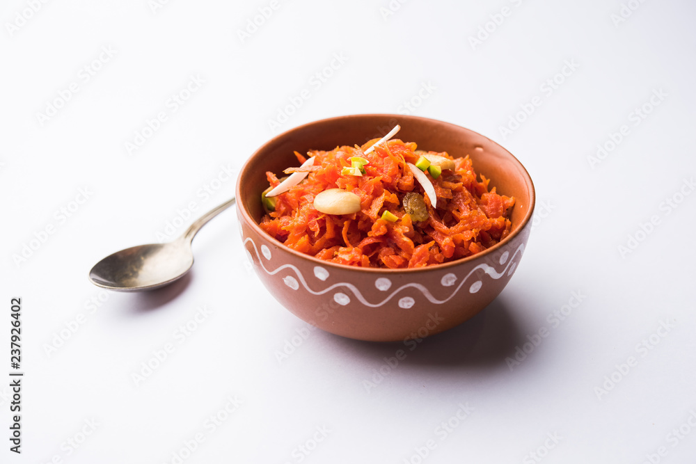 Gajar ka halwa is a carrot-based sweet dessert pudding from India. Garnished with Cashew/almond nuts. served in a bowl. - obrazy, fototapety, plakaty 