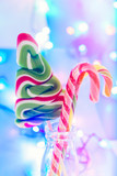 Christmas background. Caramel, bokeh, blur. Candy cane on blurred Christmas lights background