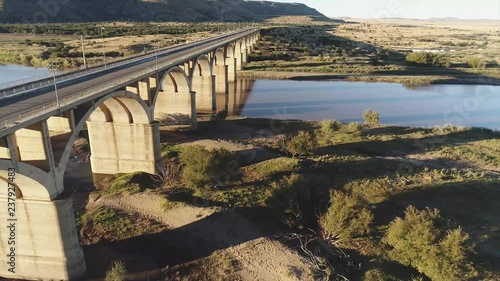 Flying Next to Arched Bridge over River in Africa