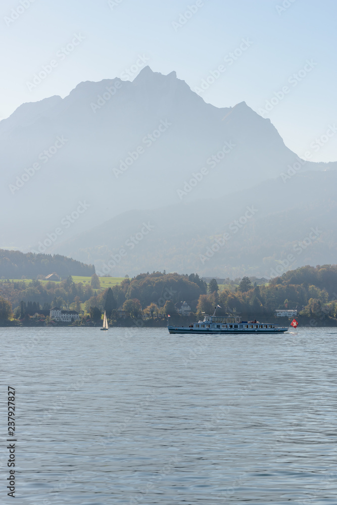 Touristic boat on the Lake of Luzern on a silhouette of Pilatus mountain Touristic boat on the Lake of Luzern on a silhouette of Pilatus mountain