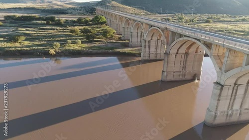 Low Fly Past Arched Bridge over River in Africa