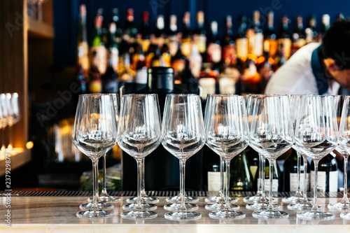 Empty wine glasses on counter table with blur wine, liquor and spirits in background.