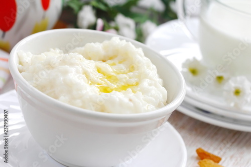 Sweet rice porridge with butter and mug of milk