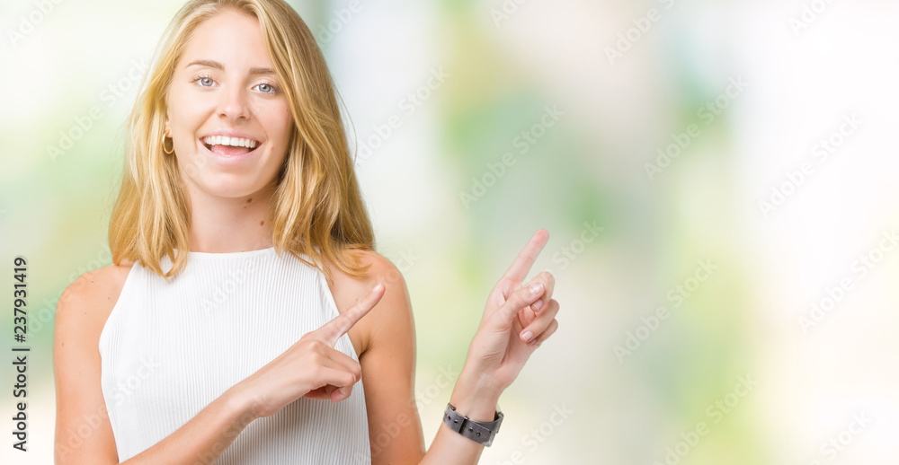Fototapeta premium Beautiful young elegant woman over isolated background smiling and looking at the camera pointing with two hands and fingers to the side.
