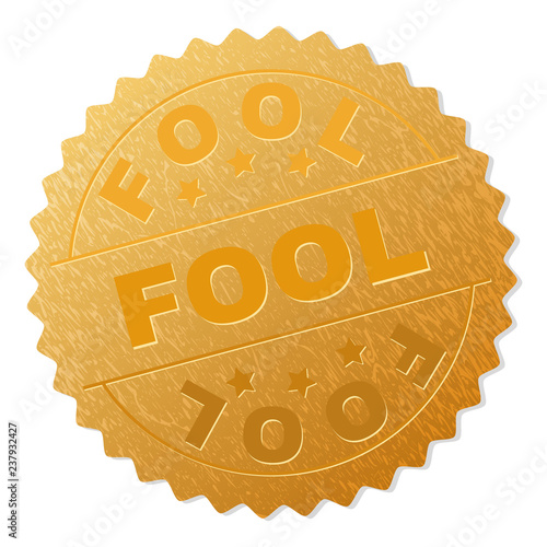 FOOL gold stamp seal. Vector golden award with FOOL text. Text labels are placed between parallel lines and on circle. Golden skin has metallic structure.