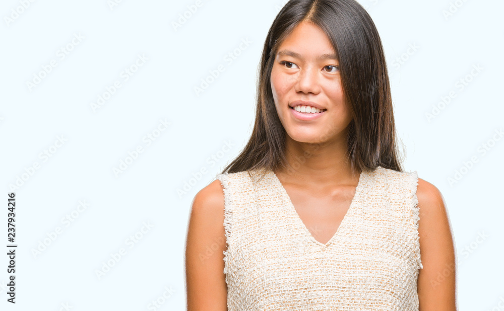 Young asian woman over isolated background looking away to side with smile on face, natural expression. Laughing confident. Young asian woman over isolated background looking away to side with smile on face, natural expression. Laughing confident.