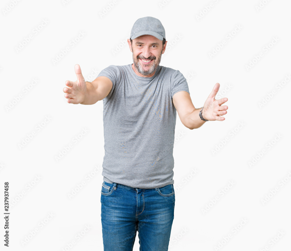 Handsome middle age hoary senior man wearing sport cap over isolated background looking at the camera smiling with open arms for hug. Cheerful expression embracing happiness. Handsome middle age hoary senior man wearing sport cap over isolated background looking at the camera smiling with open arms for hug. Cheerful expression embracing happiness.