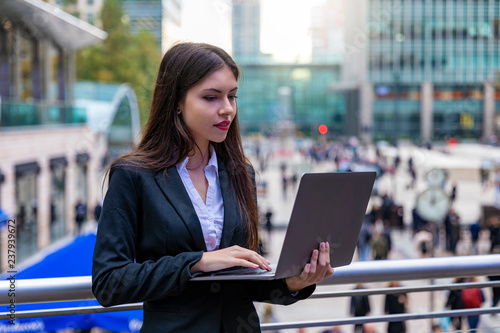 Attraktive Geschäftsfrau arbeitet am Laptop im Bankenbezirk Canary Wharf in London, Großbritannien
