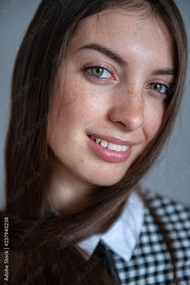 Portrait of flirtatious girl with green eyes in plaid college uniform Portrait of flirtatious girl with green eyes in plaid college uniform