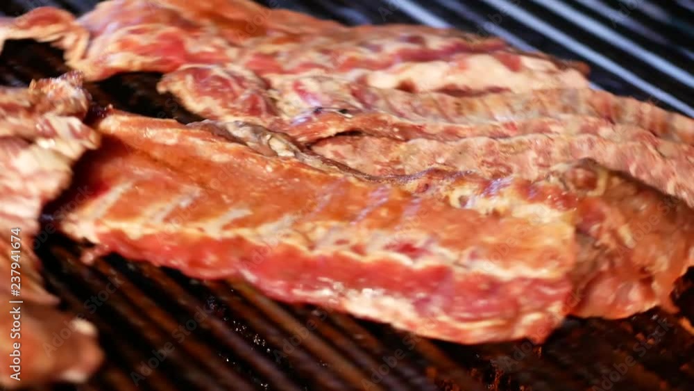 Preparation of pork ribs. Fried pork ribs spinning on the grid. Barbecue Preparation of pork ribs. Fried pork ribs spinning on the grid. Barbecue