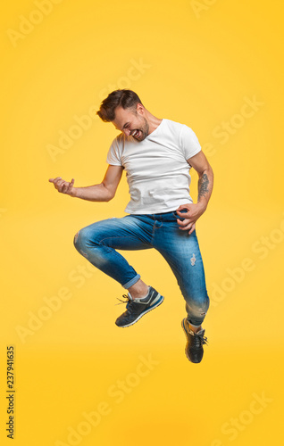 Guy jumping and playing imaginary guitar © kegfire