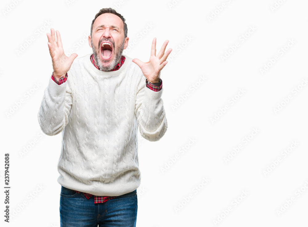 Fototapeta premium Middle age hoary senior man wearing winter sweater over isolated background crazy and mad shouting and yelling with aggressive expression and arms raised. Frustration concept.