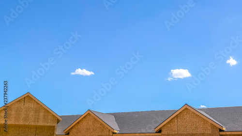 Roof of a home with sky and clouds background