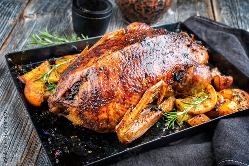 Traditional roasted Christmas duck with fruits and potatoes as top view on a board photo