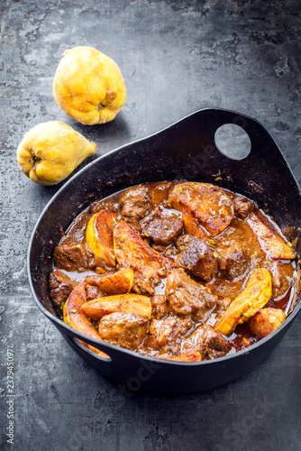 Traditional Iranian khoresh beh stew with chunks of lamb and quinces as top view in a modern style Japanese cast-iron roasting dish