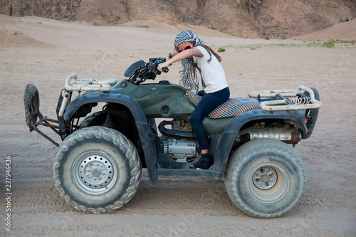 Mädchen fährt Quad durch die Wüste