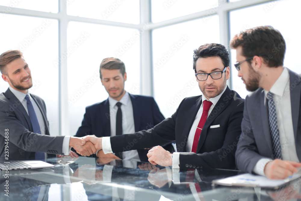 handshake of financial partners at a meeting in the office handshake of financial partners at a meeting in the office