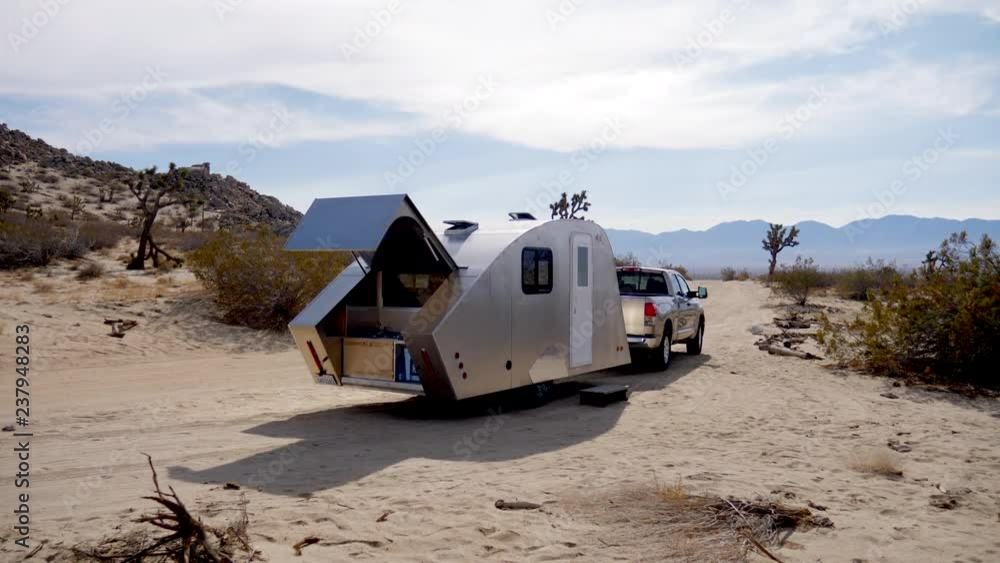 Rising shot of a teardrop travel trailer tiny house camping in the epic ...