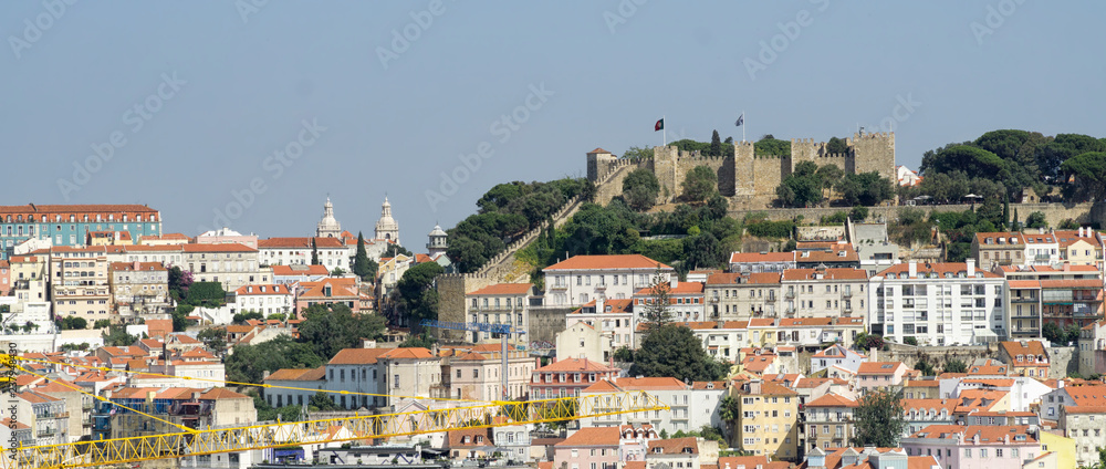 Cityscape of Lisbon, Portugal, with St George's Castle in the background. Sunny summer day, blue sky.