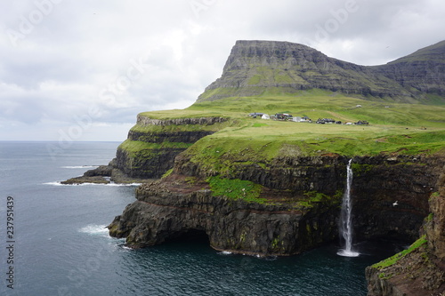 Gasadalur waterfall into the sea with clouds on the Faroe Islands in summer