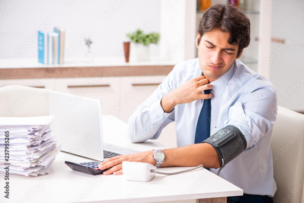 Man under stress measuring his blood pressure Man under stress measuring his blood pressure