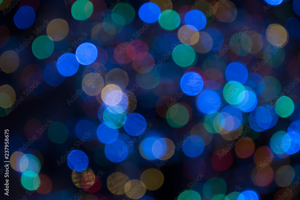 colorful bokeh background with round out of focus blurry glitter lights against black