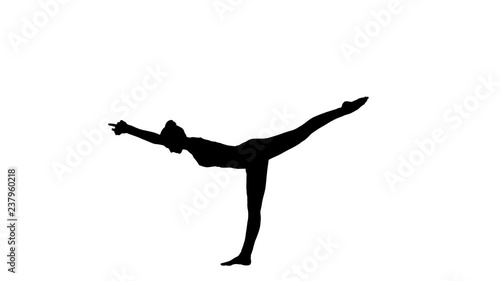 Silhouette Tuladandasana or Balancing Stick Pose is an advanced yoga posture made by beautiful yogi woman. photo