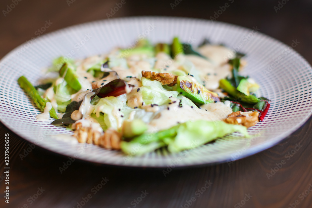 Close up Healthy salad with avocado , walnuts and grilled asparagus . Vegan food on dark wooden table. Close up Healthy salad with avocado , walnuts and grilled asparagus . Vegan food on dark wooden table.