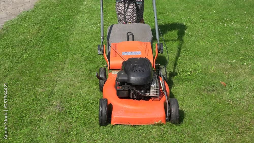 Female peasant woman in dress push lawn cut grass with mower cutter. 4K Female peasant woman in dress push lawn cut grass with mower cutter. 4K