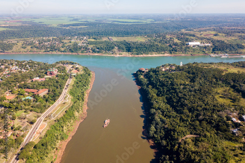 Fototapeta Naklejka Na Ścianę i Meble -  Triple Frontier, tri-border junction of Paraguay, Argentina and Brazil. Iguazú and Paraná rivers confluence. Aerial drone photo. Two color river