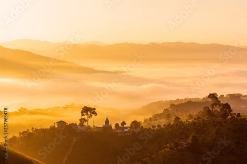 A beautiful foggy sunrise over the hills in the valley with stupa on mountain