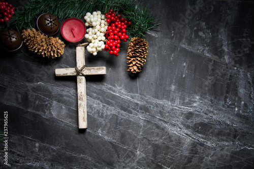 cross on black background with berries and pinecones