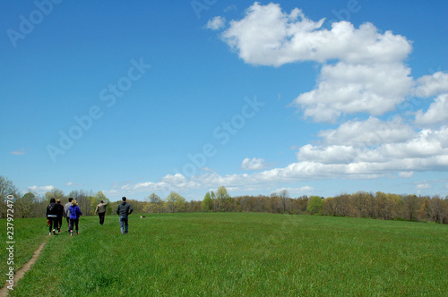 People hiking in a wide meadow under a beautiful big blue sky  © Douglas