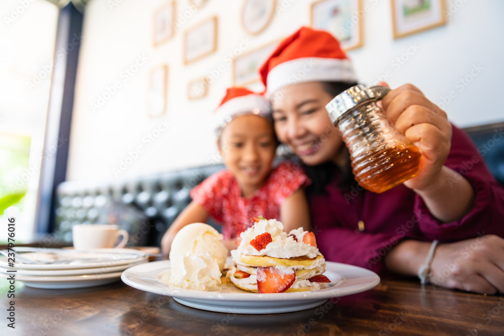 Family enjoy eating cake in Christmas Eve holiday celebration in cafe or restaurant Family enjoy eating cake in Christmas Eve holiday celebration in cafe or restaurant