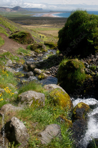 Silhouettes of two tourist hiking near a waterfall in Iceland