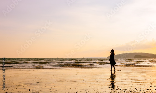 single girl enjoying herself with background of peaceful beach during sunset, photo taken on Ao Nang beach, Krabi, Thailand.