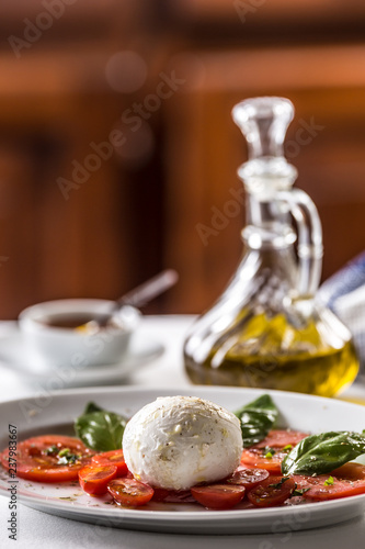 Caprese salad from mozzarella tomatoes basil olive oil an spices