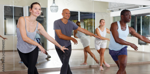 Group of multinational smiling people practicing new dance techniques
