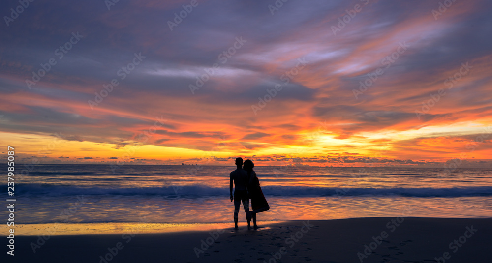 silhouette of young Asian couple during sunset, photo taken on Lanta island beach, Krabi, Thailand.