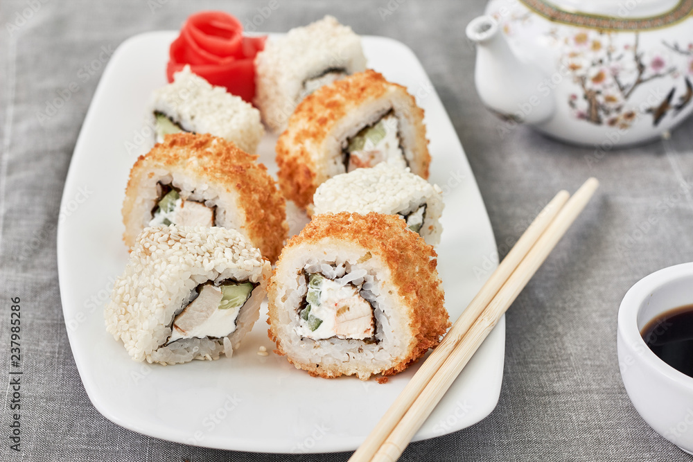 Sushi Set maki on white plate.Chopsticks, ginger and soy sauce Sushi Set maki on white plate.Chopsticks, ginger and soy sauce