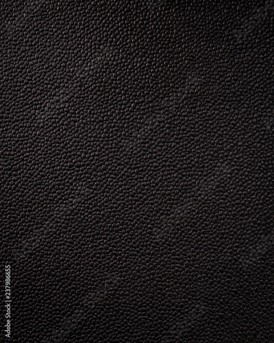 Vertical black leather texture. Synthetic material background in rough style.